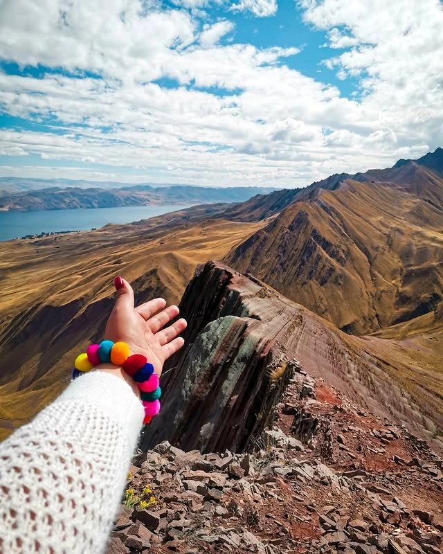 Tourist pointing at Pallay Punchu, the new Rainbow Mountain