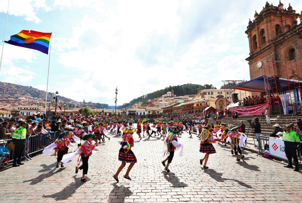 Dancers at the Cusco festival with the emblem of the Cusco flag