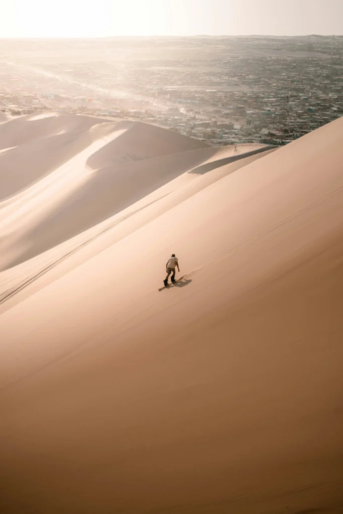 Turista praticando sandboard nas dunas de Huacachina