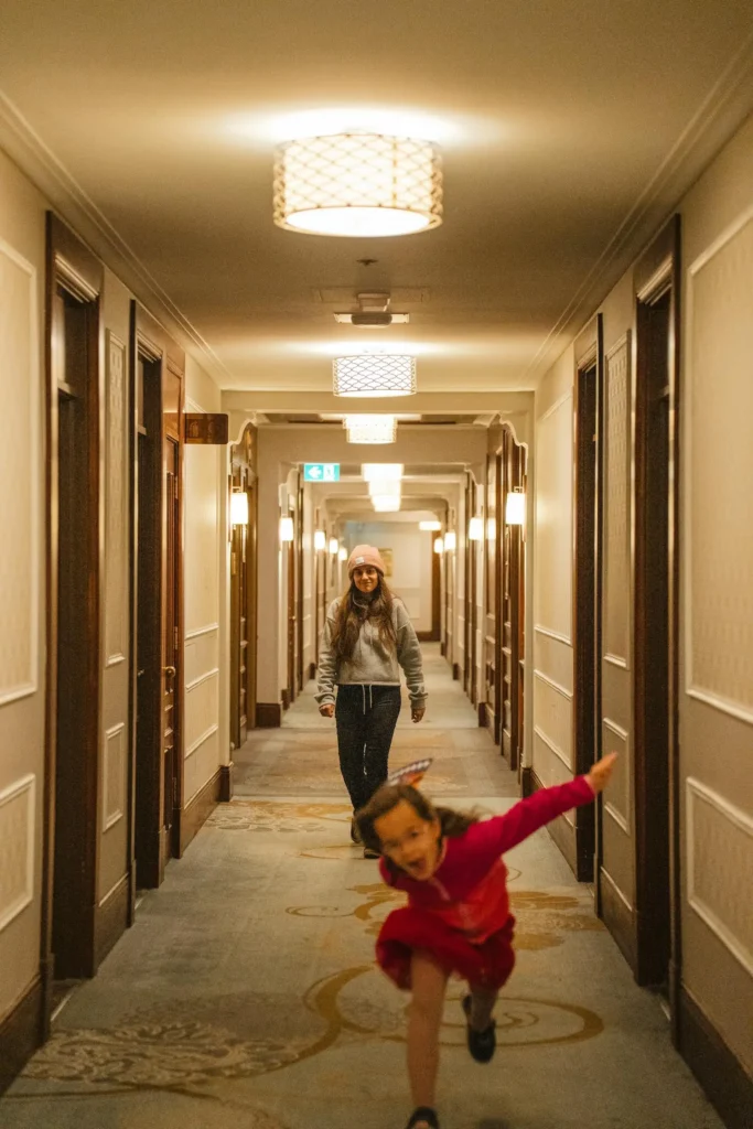 Meninas caminando pelo corredor do hotel