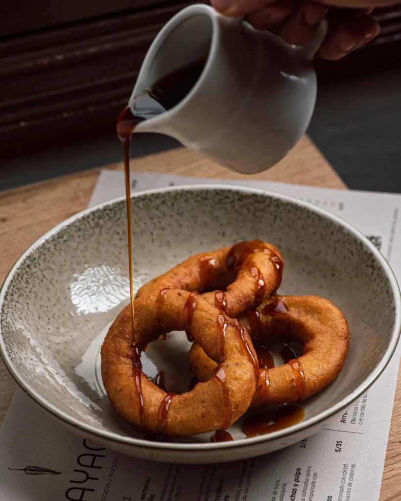 Picarones, preparados com uma massa à base de farinha e acompanhados de mel de Chancaca