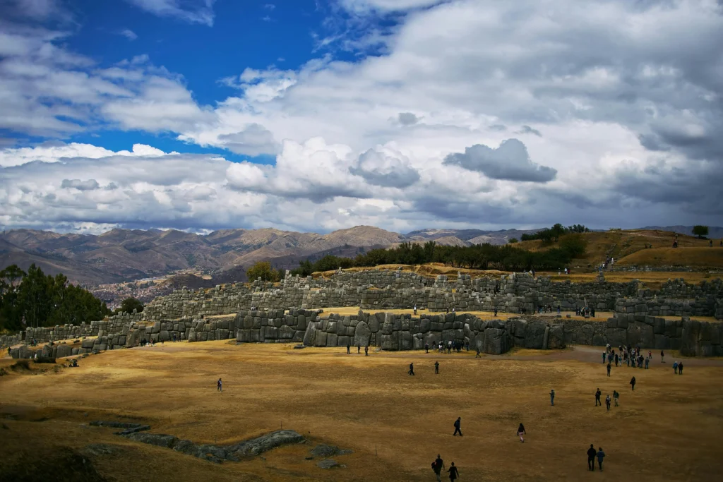 Turistas caminhando pelas ruínas do Complexo Arqueológico de Sacsayhuamán