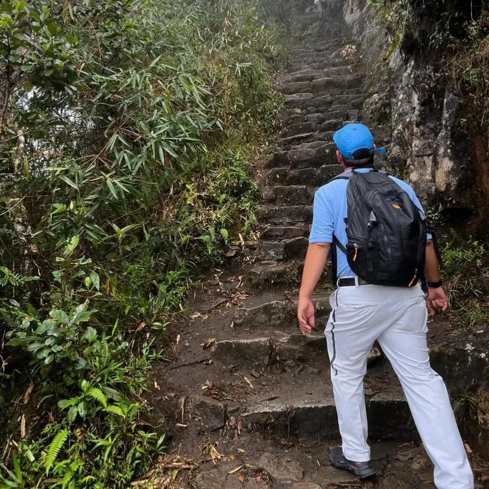 Tourist climbing the stairs to the summit of Huayna Picchu Mountain