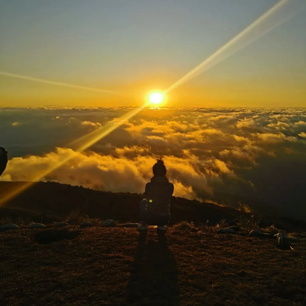 Tourist enjoying the cloud spectacle at the Tres Cruces de Oro viewpoint in Paucartambo