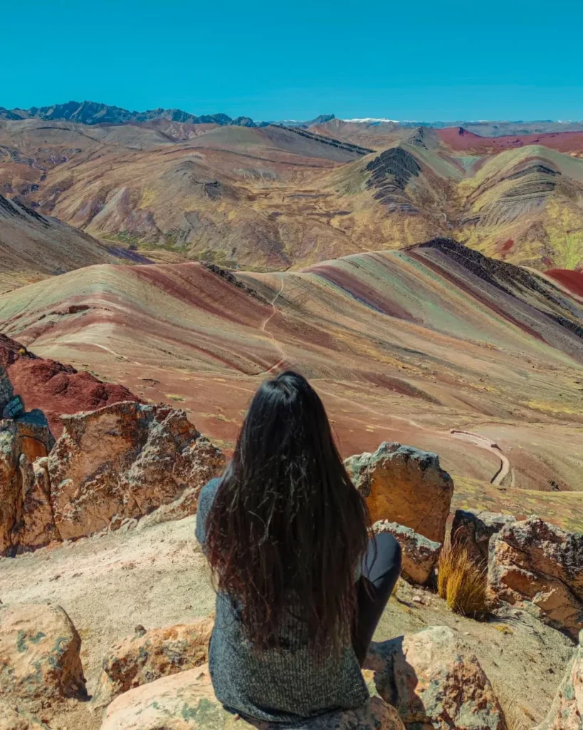 Turista sentada sobre uma rocha no bosque de pedras próximo à cordilheira de Palcoyo