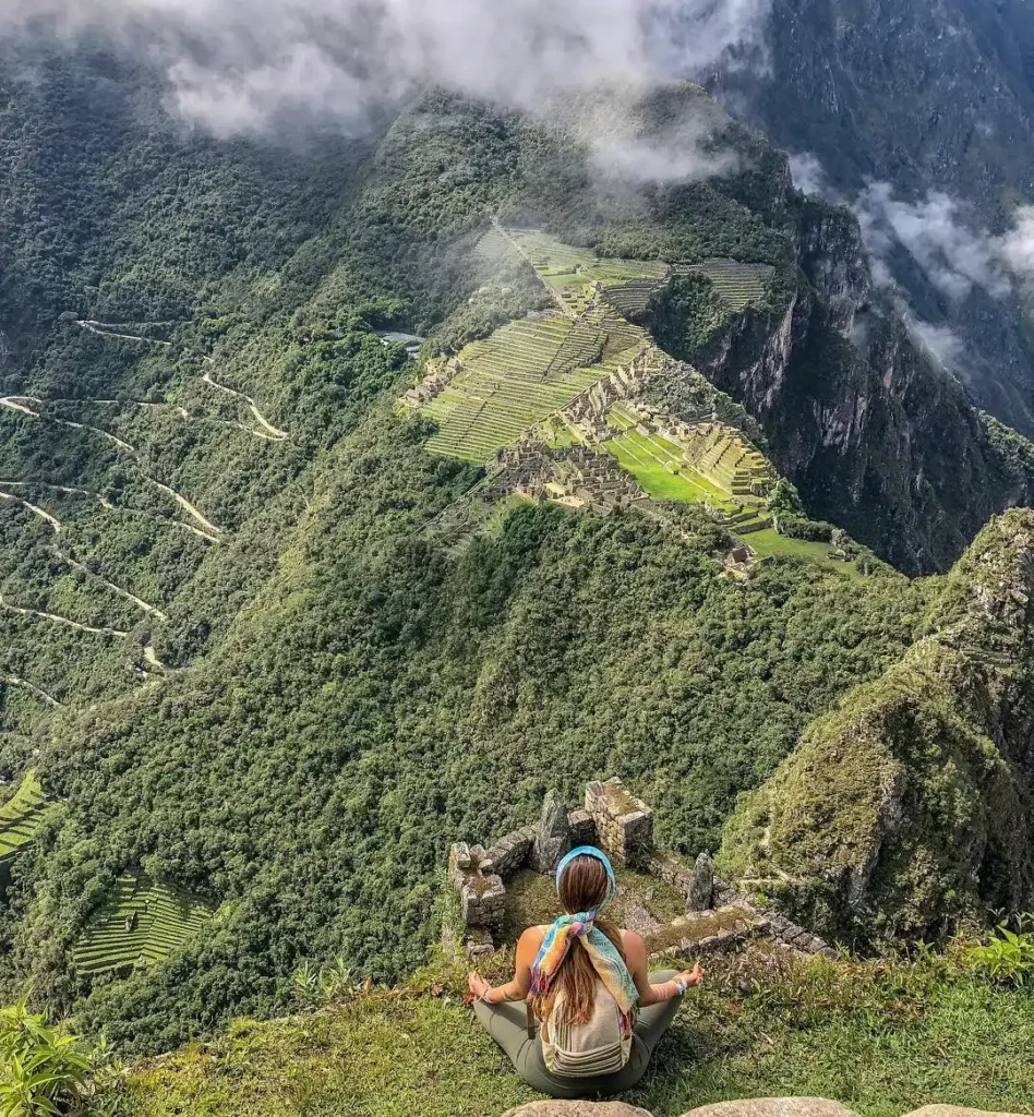 Tourist at the summit of Huayna Picchu Mountain overlooking Machu Picchu