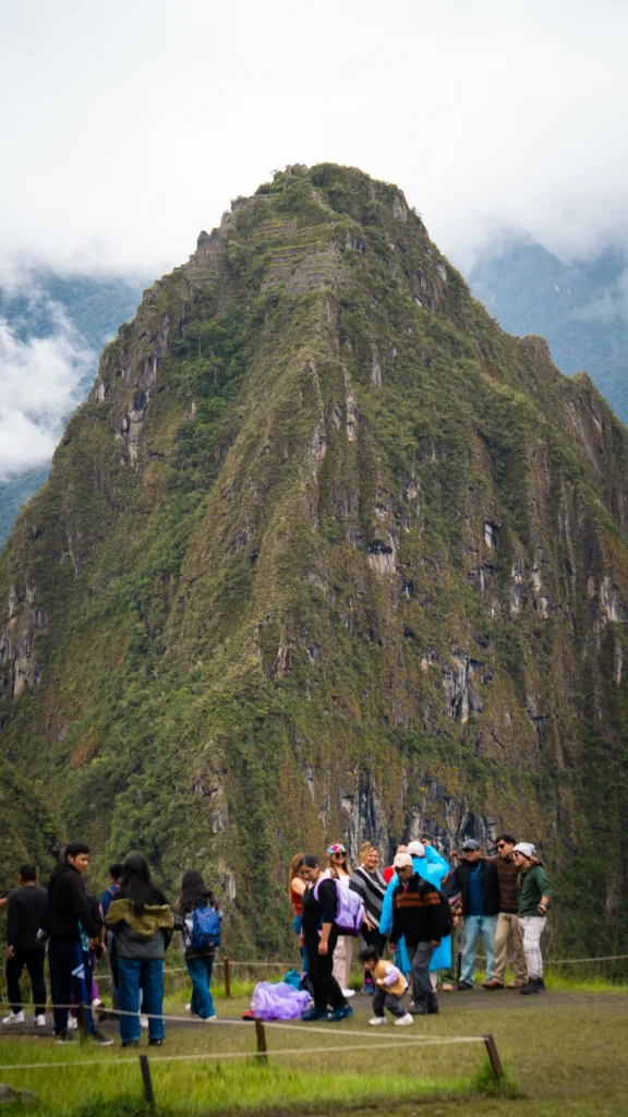 Tourists taking photos in front of Huayna Picchu Mountain