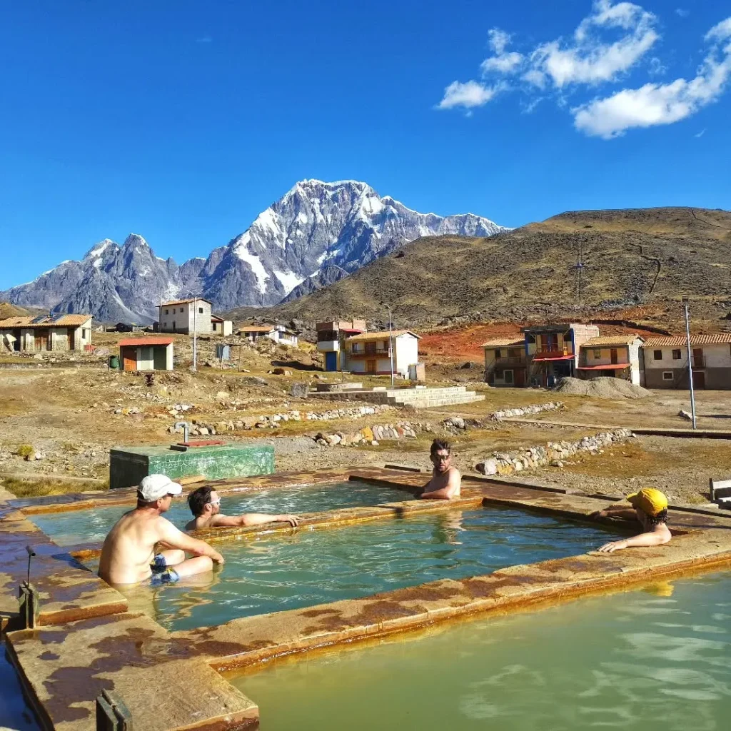 Visitantes aproveitando as fontes termais de Pacchanta e a montanha Ausangate